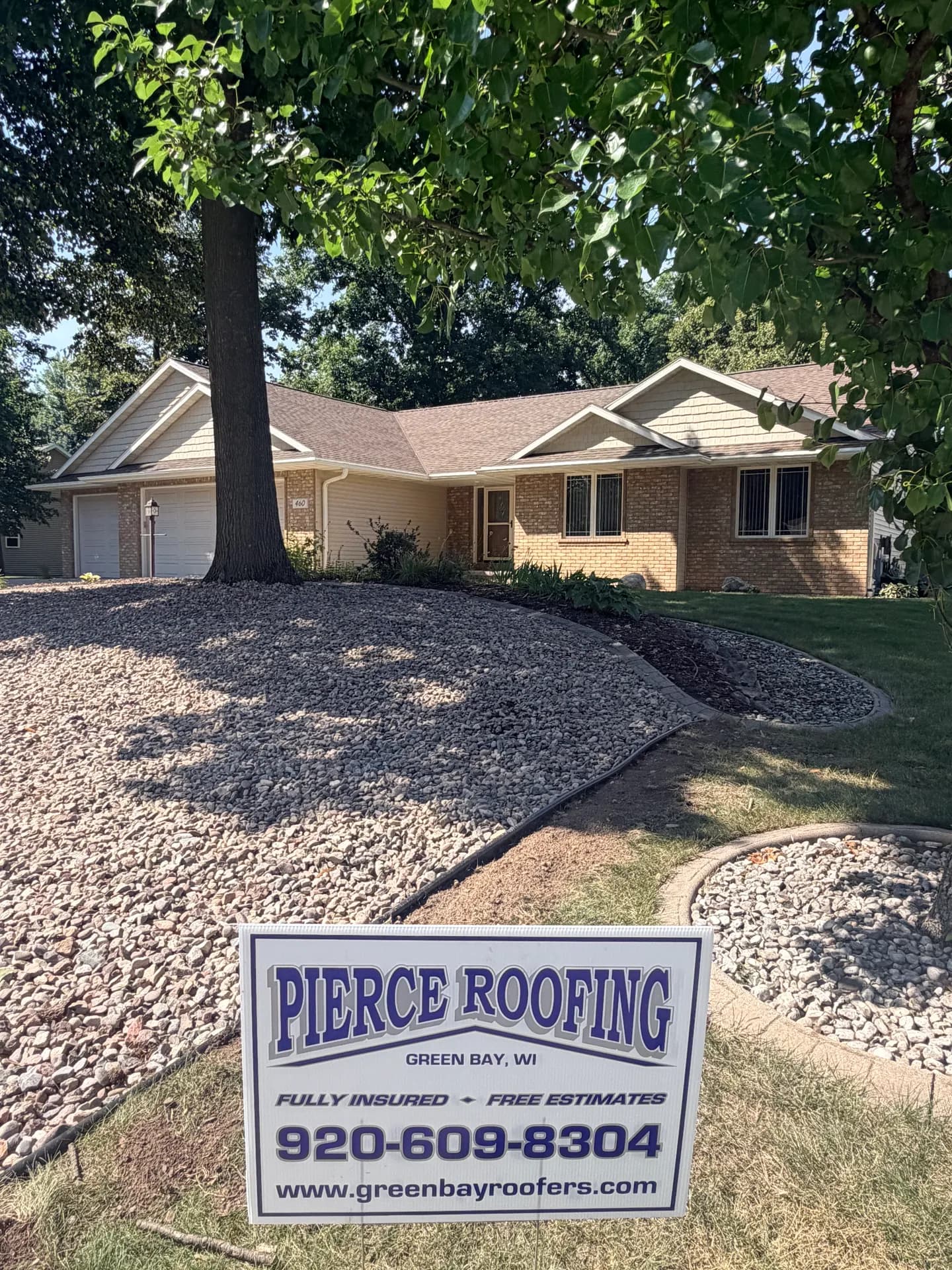 Brick ranch home with new brown architectural shingles installed by Pierce Roofing